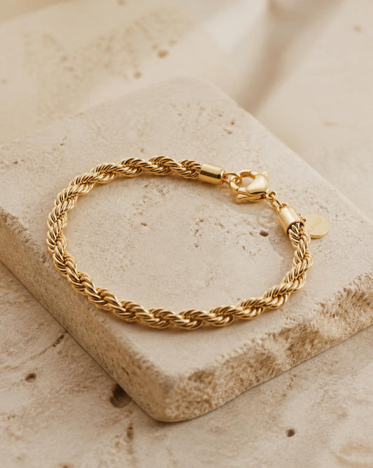 Corde gold rope chain bracelet on travertine stone